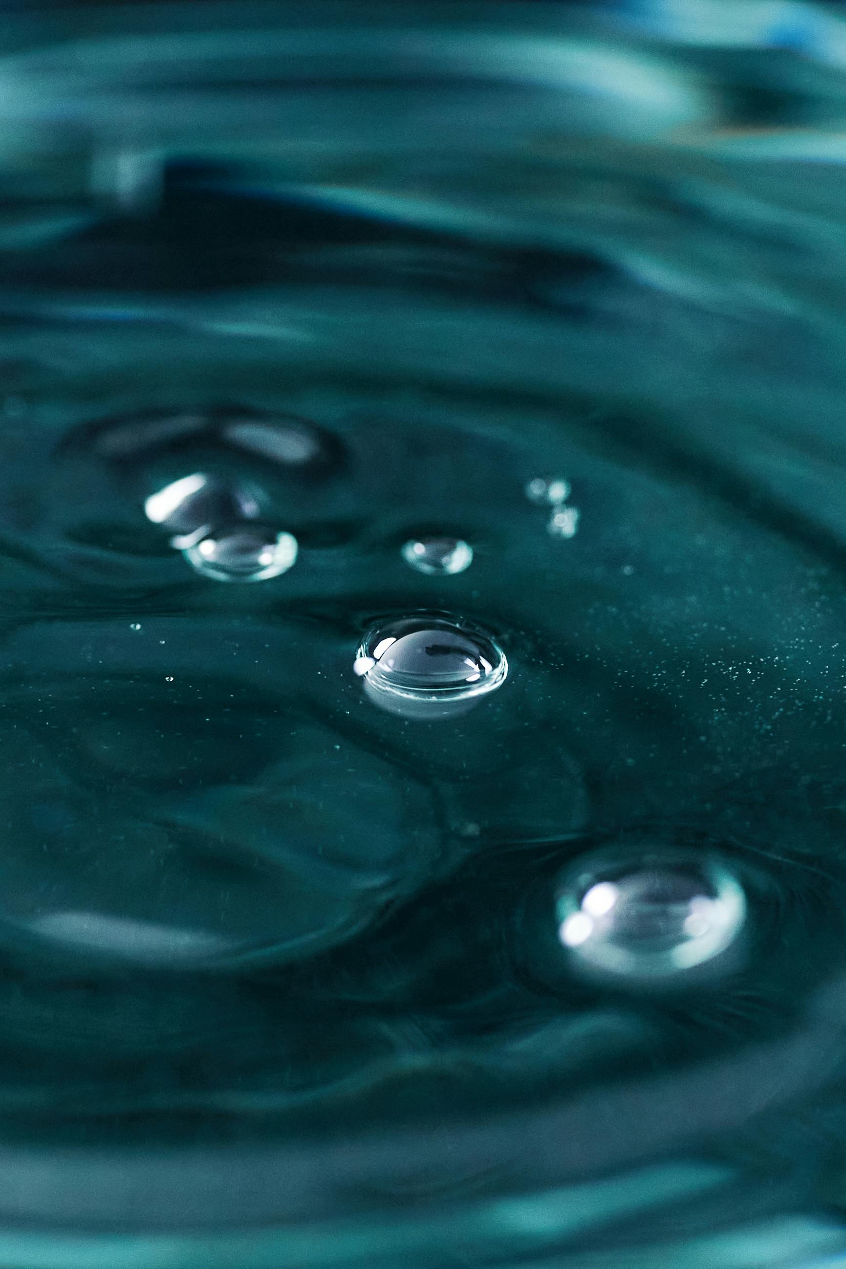 A detailed macro shot of water bubbles on a rippled surface, showcasing texture and clarity.